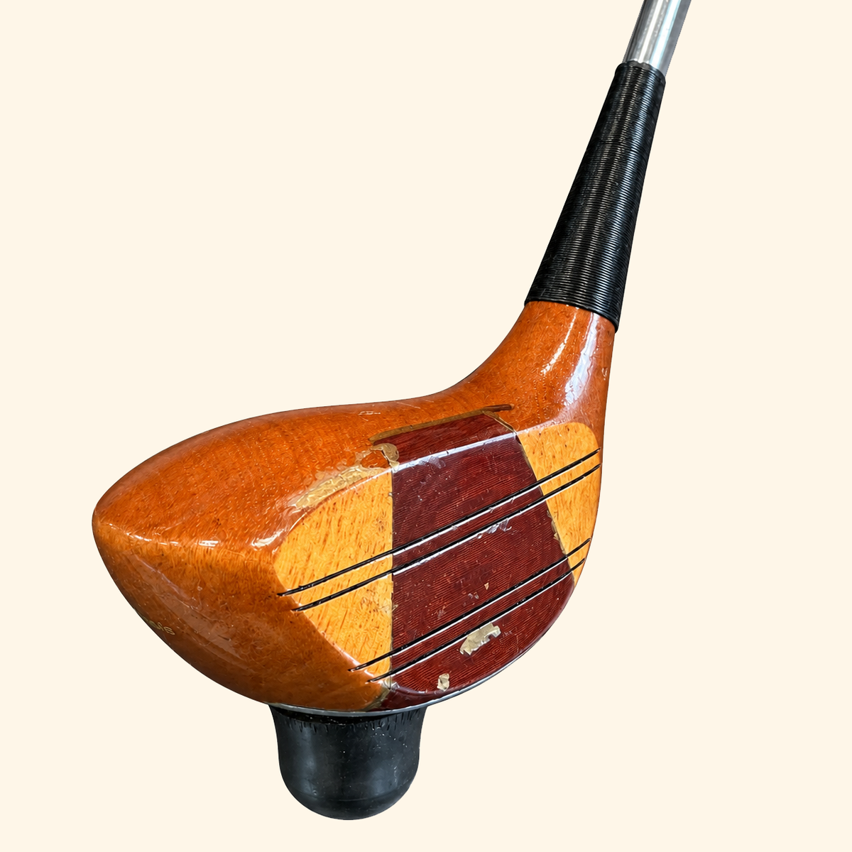 The Wilson Heritage persimmon club head side view on a cream background
